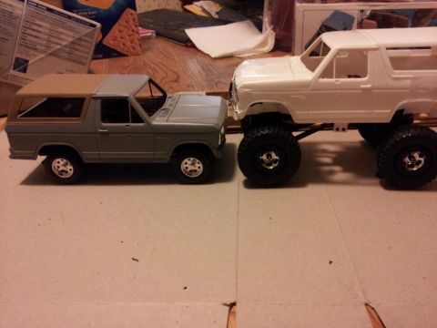 1995 Ford Bronco - Two model trucks are positioned next to each other on a flat surface.