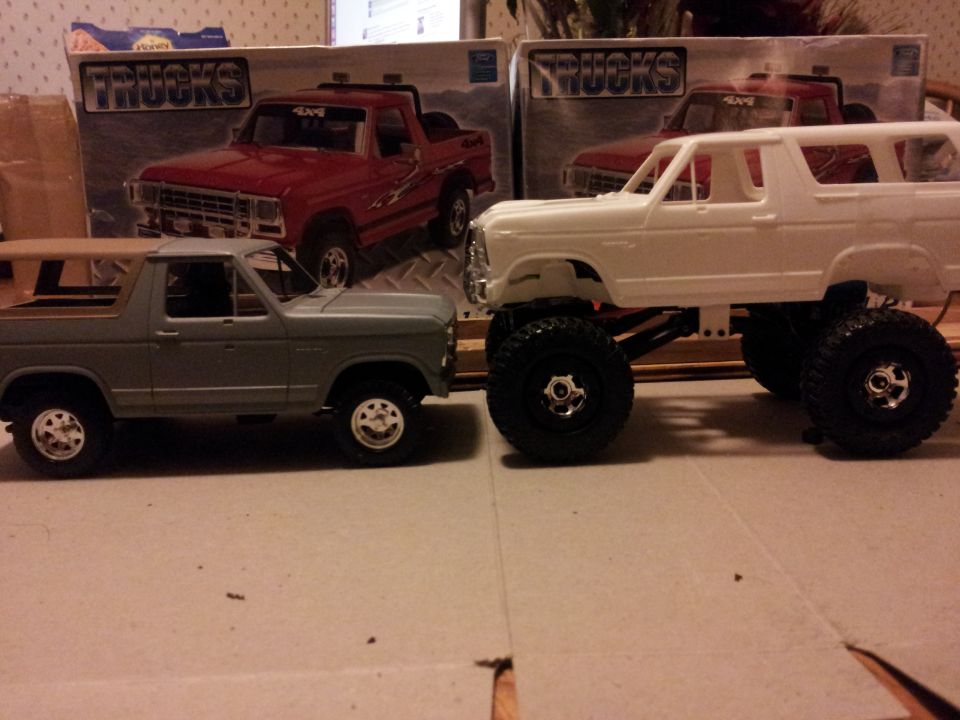 Two model trucks, one gray and one white, with "TRUCKS" boxes behind them