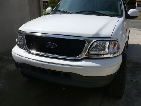 1988 Ford Bronco - Front view of a white Ford truck, likely from the late 1990s or early 2000s, a prominent Ford emblem on the grille.