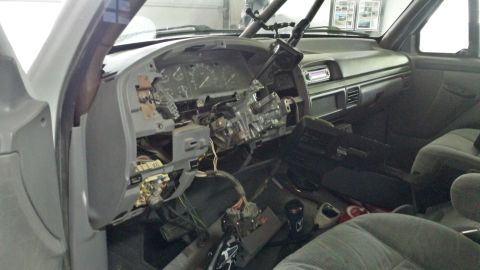 1996 Ford Bronco - Interior view of a disassembled dashboard and steering column, revealing exposed wiring and components.