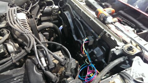 2000 Mercury Grand Marquis - Close-up view of a vehicle's engine bay, showing wiring harnesses and the radiator assembly.