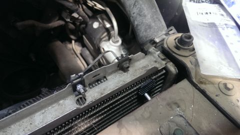 2000 Mercury Grand Marquis - Close-up view of a transmission cooler unit mounted near the vehicle's radiator.