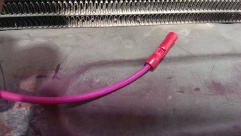 2000 Mercury Grand Marquis - A close-up view of a wire with a red connector, positioned near a radiator grille.