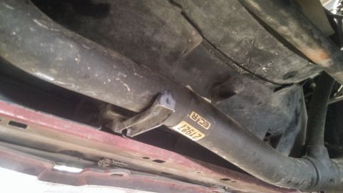 2000 Mercury Grand Marquis - Underside view of vehicle components, including an exhaust pipe with a part number label.