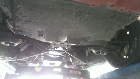 2000 Mercury Grand Marquis - The undercarriage of a vehicle is shown while it is raised on a lift for inspection or repair.