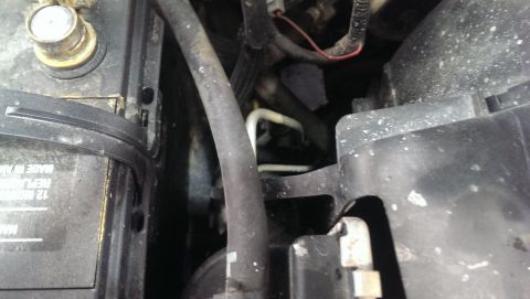 2000 Mercury Grand Marquis - Engine bay components including a battery and various hoses are seen in this close-up view.