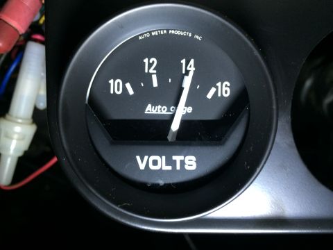 1964 Ford Ranchero - Close-up of a black Auto Meter Products voltmeter gauge, showing the needle at 14 volts.