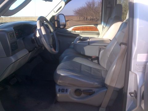 1985 Jeep CJ7 - The interior of a truck is shown, leather seats and a wood-trimmed dashboard.