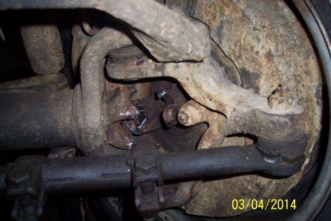 1973 Ford F-250 - This image shows a close-up view of a vehicle's steering and suspension components, including tie rods and a ball joint.