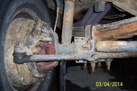 1973 Ford F-250 - Close-up view of a vehicle's front suspension and steering components, showing rust and wear.