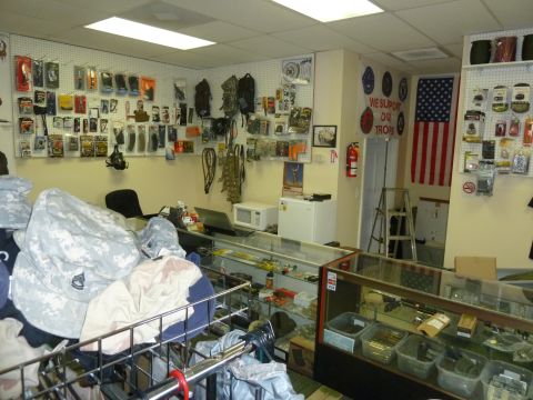 1992 Ford Mustang - Interior view of a store selling tactical gear and accessories, with merchandise displayed on walls and in cases.