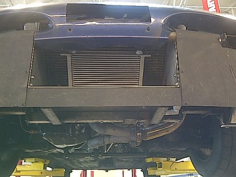 1995 Ford Probe - Underside view of a blue vehicle, revealing an aftermarket oil cooler and exhaust components.