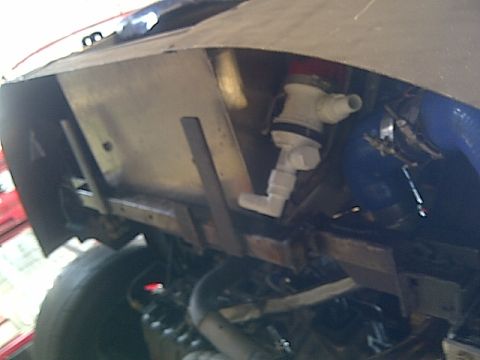 1995 Ford Probe - Close-up of underbody plumbing, showing a white valve assembly with a red cap.
