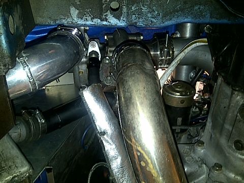 1995 Ford Probe - Custom turbocharger plumbing installation with various metal pipes and heat shielding visible.