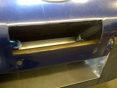 1995 Ford Probe - Close-up of a blue car's front end, showing an exposed radiator and associated plumbing.