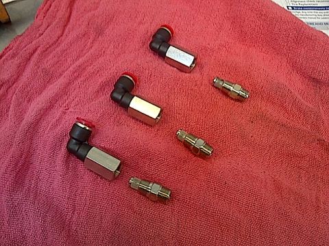 1995 Ford Probe - Pneumatic fittings and adapters are laid out on a red cloth, possibly for a vehicle repair or modification.