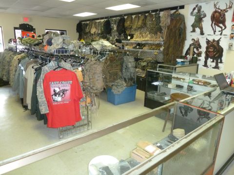1992 Ford Mustang - Store interior displays camouflage apparel, backpacks, and tactical gear, with a red t-shirt visible.