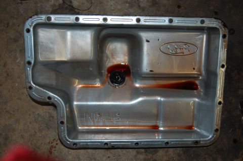 1994 Ford Bronco - A transmission pan, likely from a Ford vehicle, shows signs of fluid and wear.