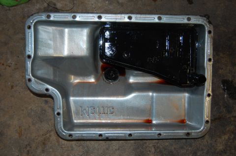 1994 Ford Bronco - A transmission pan with a filter and fluid residue, embossed text. The registry claims 1994 Ford Bronco.