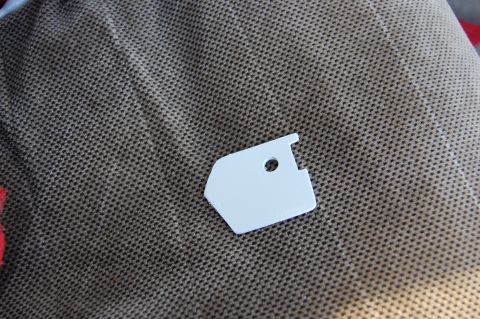 1994 Ford Bronco - A small white plastic part is shown on a brown textured surface.