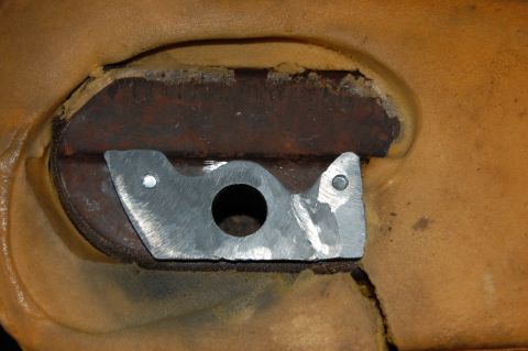 1994 Ford Bronco - Close-up of a metal bracket repair on a tan seat cushion, with visible rust and fabric wear.
