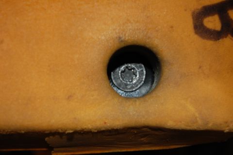 1994 Ford Bronco - A close-up view shows a Torx screw embedded in the tan upholstery of a vehicle's interior.