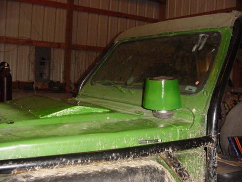 1992 Ford Bronco - A green off-road vehicle is parked inside a garage with a roll cage and a snorkel intake visible.