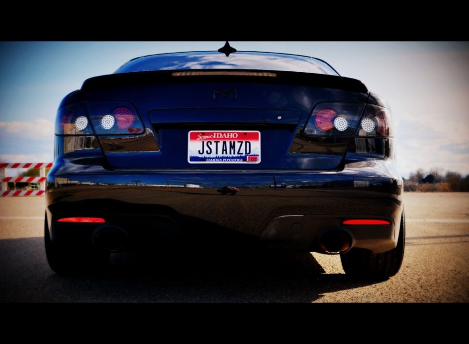Dark blue Mazda sedan rear view with Idaho license plate JSTAMZD