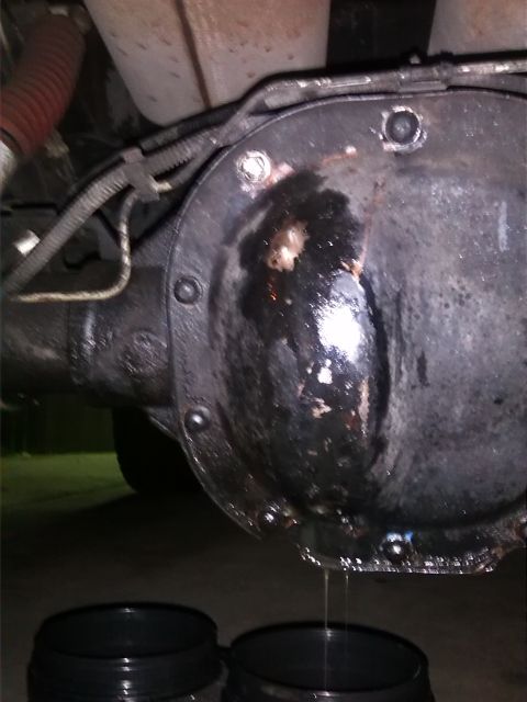 1992 Ford Bronco - A rear differential is shown leaking fluid into containers, with a red hose visible nearby.