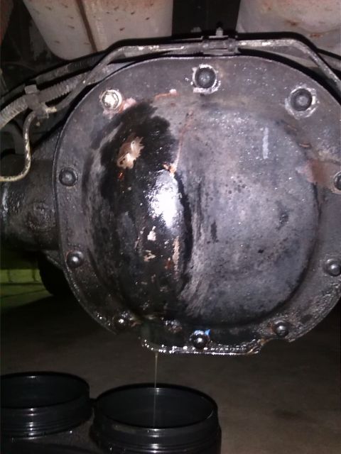 1992 Ford Bronco - Differential cover is leaking fluid, with two black containers catching the drips.