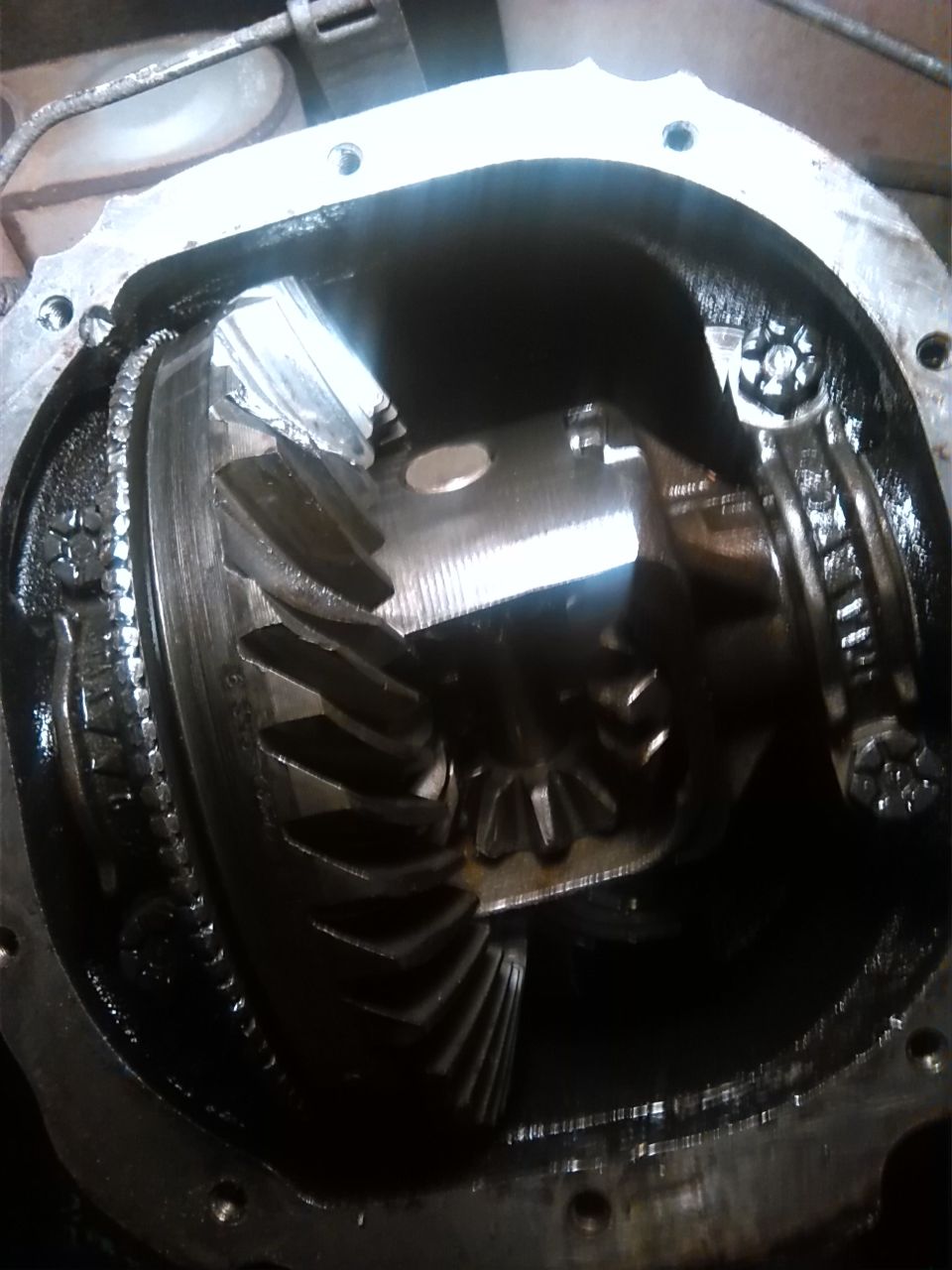 Differential gears with chipped teeth inside a metal housing, close-up view