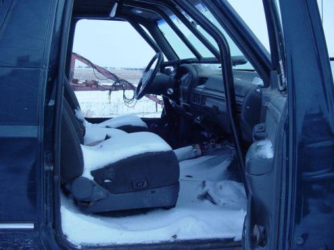 1992 Ford Bronco - The interior of a 1992 Ford Bronco is visible, with snow covering the seats and floor.