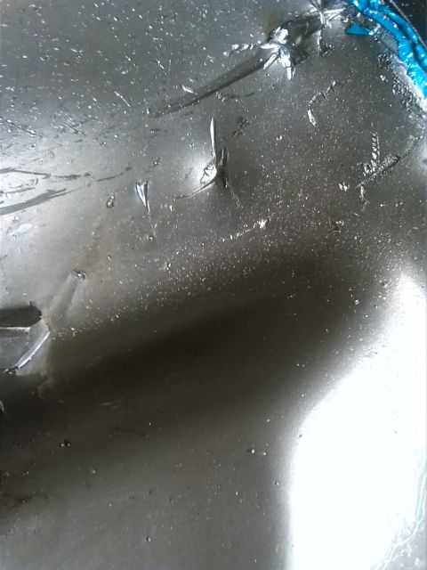 1992 Ford Bronco - This image shows a damaged metal surface, possibly from a vehicle part, with a visible Supermotors logo.