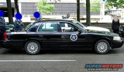 1991 Ford Crown Victoria - A black sedan marked "U.S. MARSHAL" is seen parked on a street, likely a later model Ford Crown Victoria.
