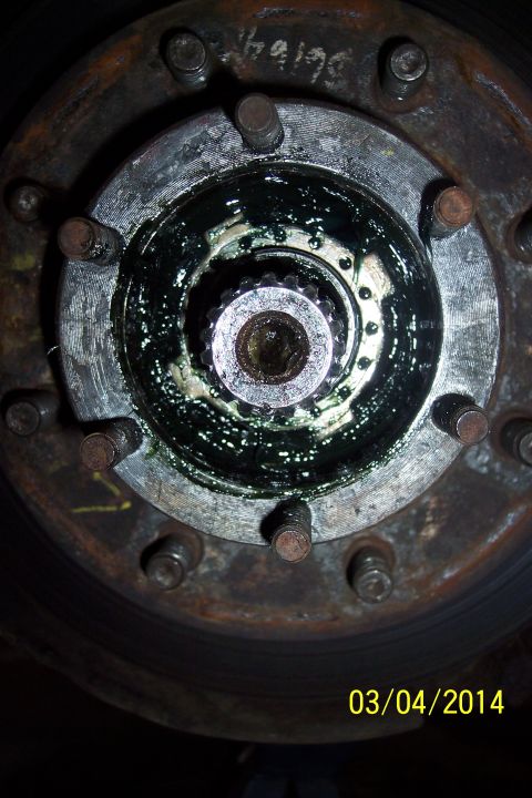 1973 Ford F-250 - Greasy wheel hub assembly with visible studs and splined axle shaft.