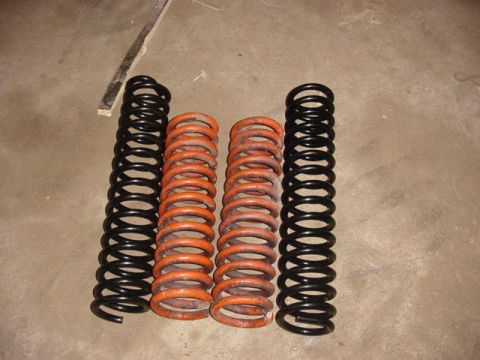 1992 Ford Bronco - Two sets of suspension springs are shown on a concrete surface.