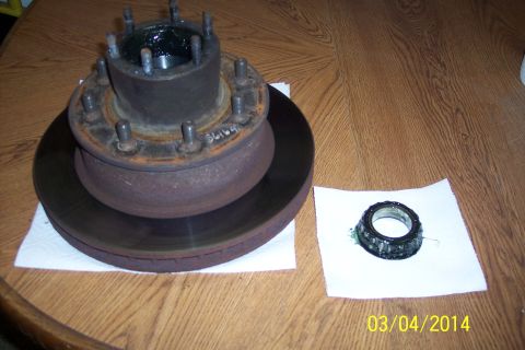 1973 Ford F-250 - A disassembled wheel hub and bearing assembly sits on a wooden table, awaiting reassembly or replacement.