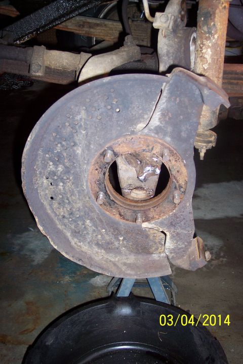 1973 Ford F-250 - A close-up view of a vehicle's brake rotor and dust shield, showing signs of wear and rust.