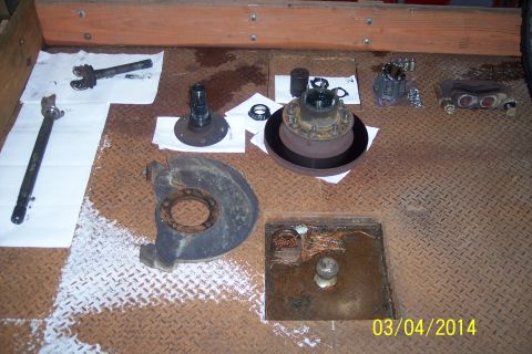 1973 Ford F-250 - Various components of a front knuckle-joint assembly are displayed, including axles, hubs, and brake parts.