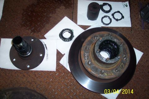 1973 Ford F-250 - Disassembled parts of a vehicle's wheel hub and brake system are laid out for maintenance.