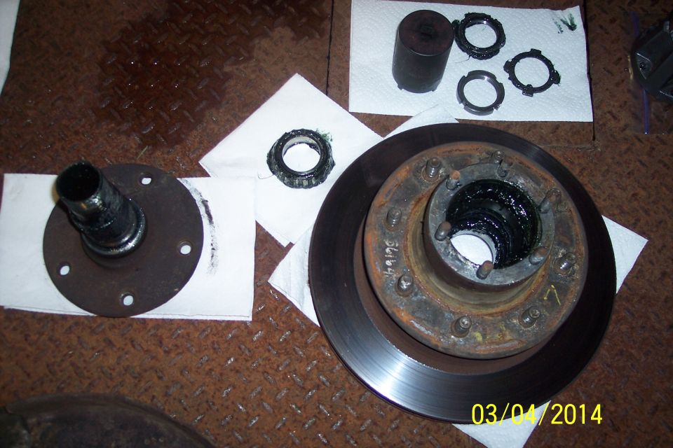 Vehicle hub, brake rotor, bearings, and seals laid out on paper towels