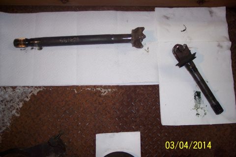 1973 Ford F-250 - Automotive parts, a knuckle-joint and an axle shaft, are laid out on paper, with one part showing a part number.