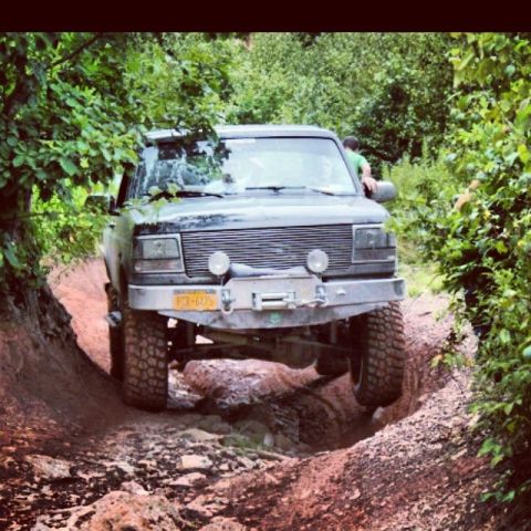 1995 Ford Bronco - This 1995 Ford Bronco tackles a challenging off-road course, demonstrating its capabilities on a steep dirt path.