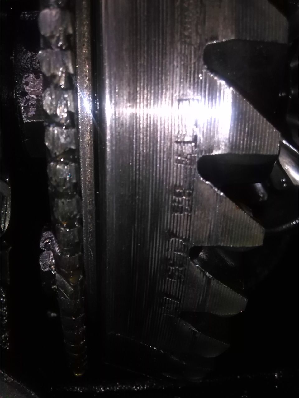 Close-up of damaged differential gears with visible part numbers