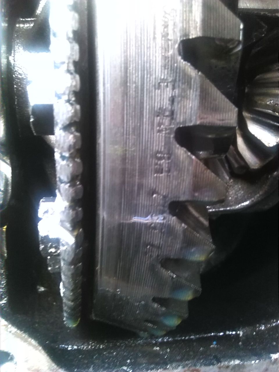 Close-up of differential gears with visible serial numbers etched on the housing