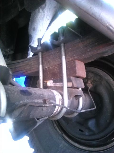 1992 Ford Bronco - Close-up view of the rear axle leaf spring suspension system, showing U-bolts and auxiliary blocks.