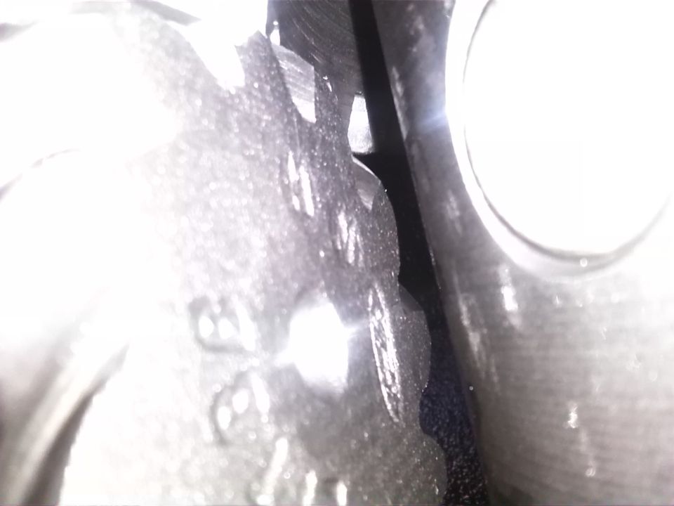 Close-up of a metal gear with teeth, possibly from an engine