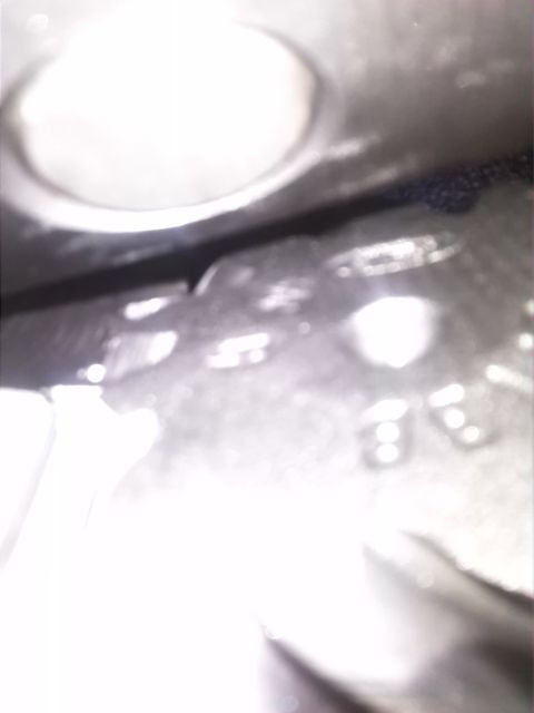 1992 Ford Bronco - A blurry close-up of a vehicle component, possibly a stamped metal piece.