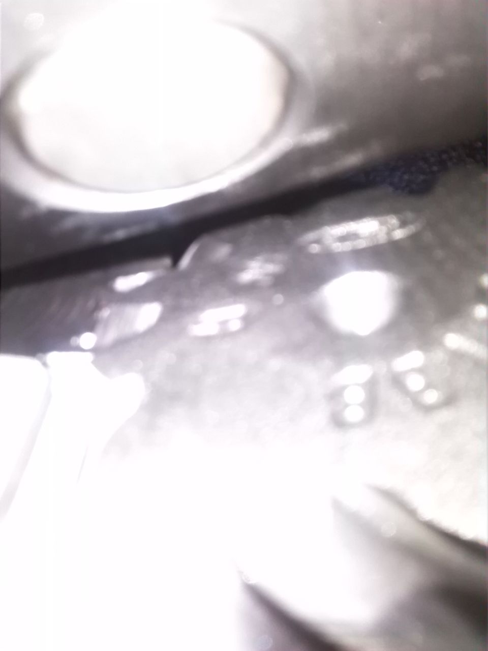 Close-up of a metal part with visible stamping and a circular indentation