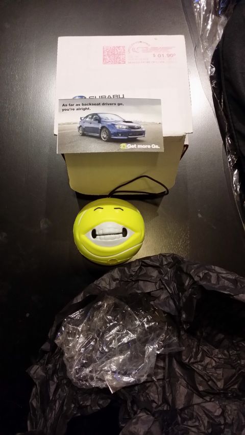 2007 Subaru Impreza - Advertisement card for Subaru Impreza sits atop a box next to a novelty item.